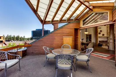 an outdoor patio with a glass table and chairs at Downtown Penthouse condo in South Lake Tahoe