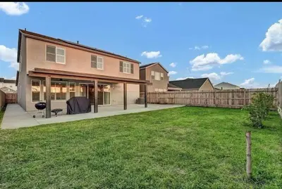 a house with a yard with a fence at Joyhouse in Visalia