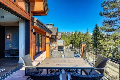 a deck with a wooden table and chairs on a balcony at Crystal Bay Penthouse 301 condo in Crystal Bay