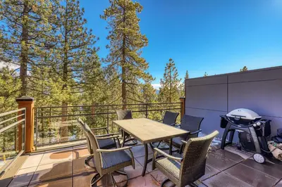 a deck with a table and chairs and a grill at Crystal Bay Penthouse 301 condo in Crystal Bay