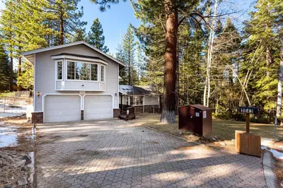 a white house with a tree and a driveway at Panhandle House home in South Lake Tahoe