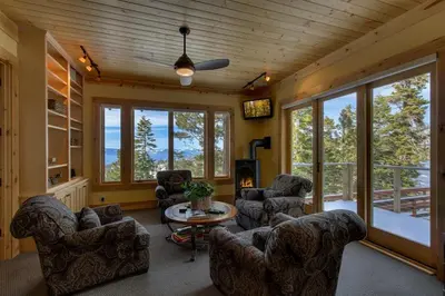 a living room with couches and a table and windows at Rock Haven condo in Stateline