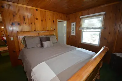 a bedroom with a bed in a wooden cabin at Lakeside Cabin with lake view in Bass Lake