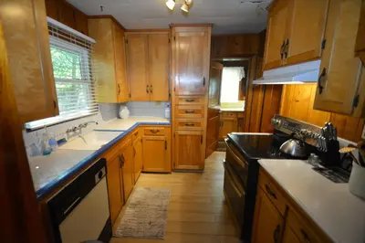 a kitchen with wooden cabinets and a stove top oven at Lakeside Cabin with lake view in Bass Lake