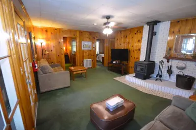 a living room with a couch and a stove at Lakeside Cabin with lake view in Bass Lake
