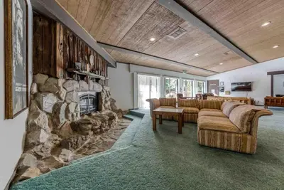 a living room with a couch and a stone fireplace at TahoeCozy with Pool Hot Tub and Near Northstar in Tahoe Vista