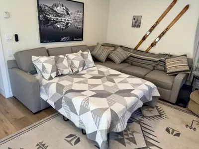 a living room with a bed and a couch at Fireside Condo at the Village - Remodeled in Mammoth Lakes