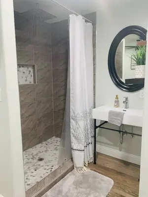 a bathroom with a shower curtain and a sink at Rustic Retreat 3 bd/2 bth - Large Family Game Area in Fresno