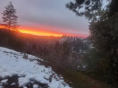 a sunset in the mountains with snow on the ground at Peaceful Pines Place, a cozy mountain hideaway wAC