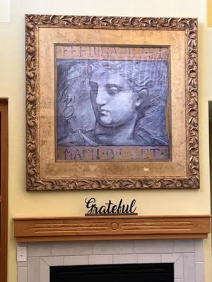a painting of a man over a fireplace at la paz private room with jacuzi in Fresno