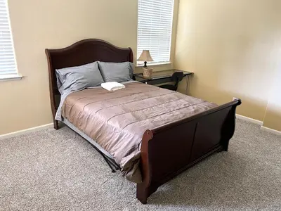 a bedroom with a large bed with a wooden frame at la paz private room with jacuzi in Fresno