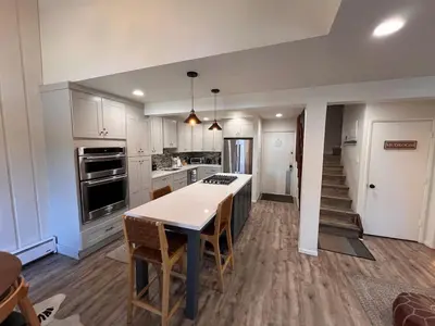 a kitchen with white cabinets and a table and chairs at Cozy Mtn Condo - Hot Tub - Walk to Canyon Lodge in Mammoth Lakes