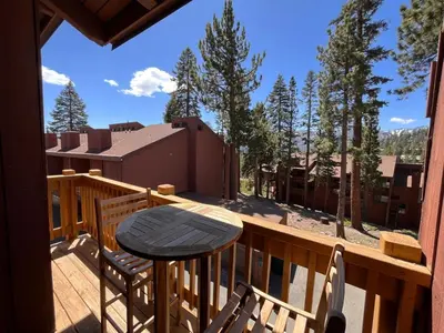 a wooden deck with a table and chairs on it at Cozy Mtn Condo - Hot Tub - Walk to Canyon Lodge in Mammoth Lakes
