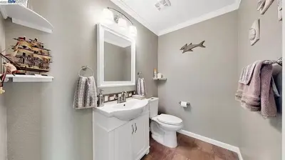 a bathroom with a sink and a toilet and a mirror at Waterfront Sleeps 6 near Marina with Hot Tub in Discovery Bay