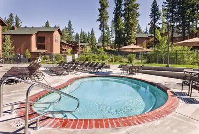 a swimming pool with chairs and tables and a building at Wyndham South Shore 1BR Apartment with Resort Access in Zephyr Cove