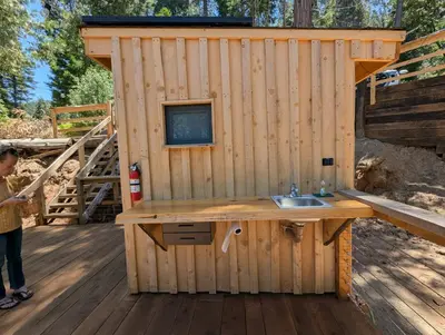 a wooden out house with a sink on a deck at Big Woods Retreat in Miramonte