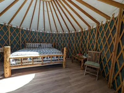 a bedroom in a yurt with a bed and a table at Big Woods Retreat in Miramonte