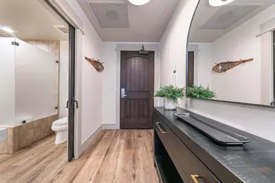 a bathroom with a sink and a toilet and a mirror at Catamount Lodge 101A by East West Hospitality in Truckee