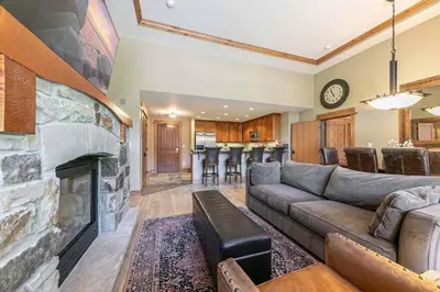 a living room with a couch and a fireplace at Catamount Lodge 101B by East West Hospitality in Truckee