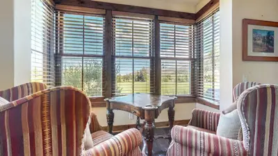 a room with chairs and a table and windows at Snowcreek VI The Lodges #1197 condo in Mammoth Lakes