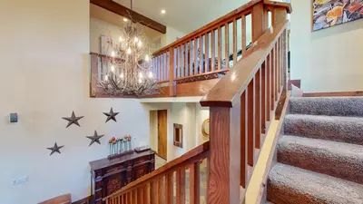a wooden staircase with a chandelier and stars on the wall at Snowcreek VI The Lodges #1197 condo in Mammoth Lakes