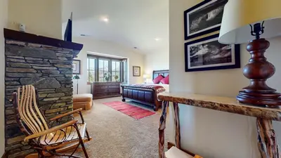 a living room with a stone fireplace and a bedroom at Snowcreek VI The Lodges #1197 condo in Mammoth Lakes