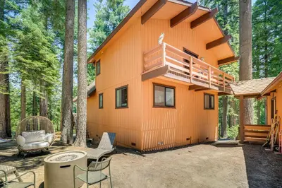 a cabin in the woods with a deck and chairs at Cabin Getaway Near Big Trees Park Game Room, Deck in Camp Connell