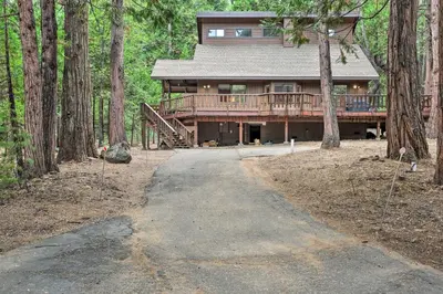 a house in the woods with a path leading to it at Game Room and Deck Pet-Friendly Camp Connell Cabin in Camp Connell