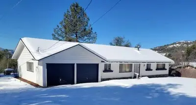 a white house with a snow covered roof at Family Fun-Dogs ok-Bass lake-Yosemite-Sleeps 8 in Oakhurst