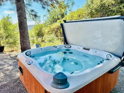a jacuzzi tub sitting next to a tree at Family Fun-Dogs ok-Bass lake-Yosemite-Sleeps 8 in Oakhurst