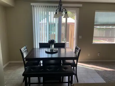 a dining room with a table and chairs and a window at Furnished five bedroom and gated community in Patterson
