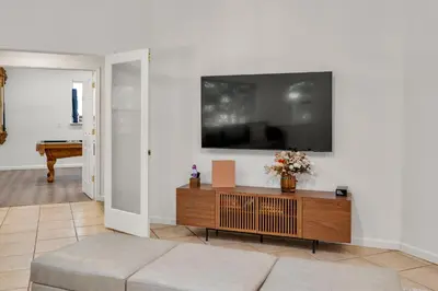 a living room with a couch and a tv on a wall at Yosemite-bound, Fun at the lake, Spacious & stylish 6 Bdr home with game room in Groveland