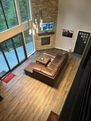 a leather couch in a living room with a fireplace at Mariposa Grove Creekside Retreat - To be featured on STAYCATION on the Destination Channel in 2026! in Fish Camp