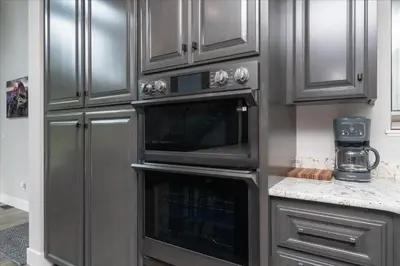 a kitchen with gray cabinets and an oven at Mariposa Grove Creekside Retreat - To be featured on STAYCATION on the Destination Channel in 2026! in Fish Camp