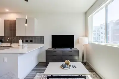 a white kitchen with a tv and a table at Landing at RED in Reno