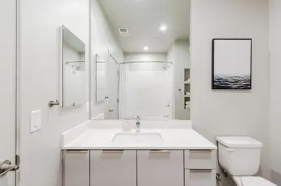 a white bathroom with a sink and a toilet at Landing at RED in Reno