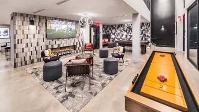 a room with a pool table and a tv at Landing at RED in Reno