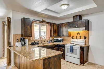 a kitchen with wooden cabinets and a white stove top oven at Updated Home in Suburbs - 10 Mi to Dtwn Stockton! in Stockton