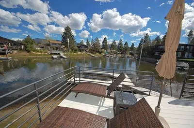 a boat with two chairs and an umbrella and water at 2078 Traverse Court home in South Lake Tahoe