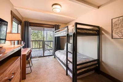 a bedroom with two bunk beds and a desk at Northshore Lakeside Condo 15 by Tahoe Getaways - Walk to Beach with HOA in Tahoe City