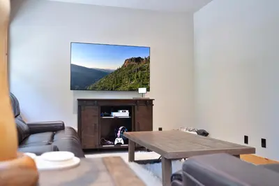 a living room with a couch and a flat screen tv at Big Chief River Retreat-Located on Truckee River in Truckee