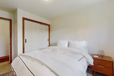 a bedroom with a white bed and a wooden table at West End Escape in Truckee