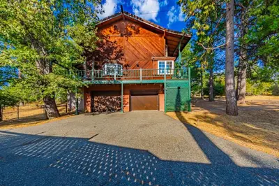 a large house with a balcony on top of it at Vintage Sunset Villa by Bass Lake 17 miles from Yosemite National Park in Oakhurst