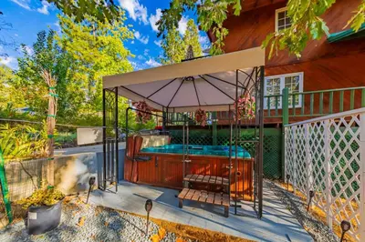 a hot tub in a gazebo next to a house at Vintage Sunset Villa by Bass Lake 17 miles from Yosemite National Park in Oakhurst