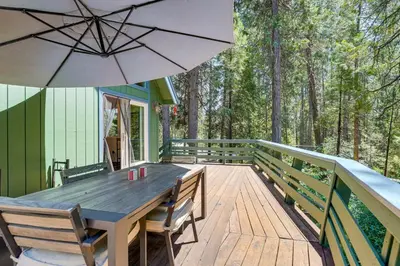 a wooden deck with a table and an umbrella at Private Lake Access Pet-Friendly Home in Arnold! in Arnold