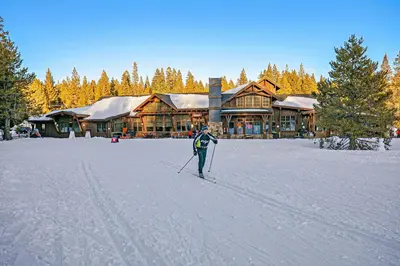 a person on skis in the snow in front of a lodge at Wintergreen at Tahoe Donner by Tahoe Getaways - 3BR w HOA! in Truckee