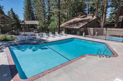 a swimming pool in a yard with chairs and a house at Dollar Hill II # 61 By Hauserman Rentals in Tahoe City