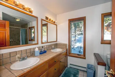 a bathroom with two sinks and two mirrors at Alpine Retreat By Hauserman Rentals in Tahoe City