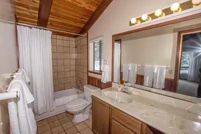 a bathroom with a sink and a toilet and a mirror at Big Pine By Hauserman Rentals in Tahoe City