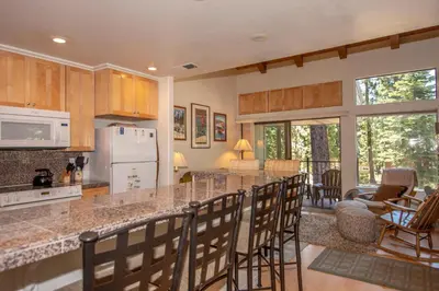 a kitchen and living room with a counter and chairs at Carnelian Woods # 11 By Hauserman Rentals in Carnelian Bay